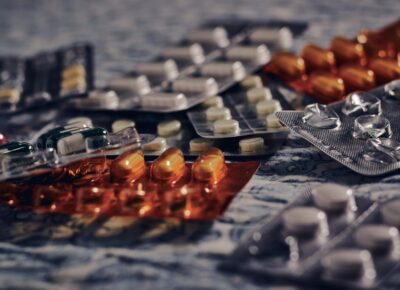 Pills and tablets on the fabric under the lights with a blurry background - medical concept A closeup of pills and tablets on the fabric under the lights with a blurry background - medical concept